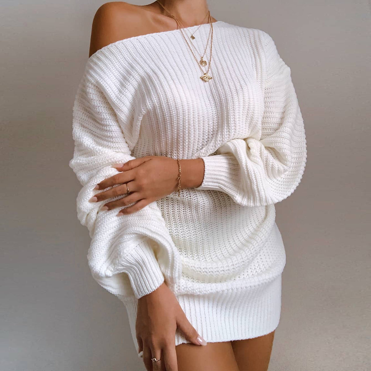 Femme portant une robe pull courte à épaules dénudées